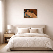 Unframed poster print of Amedeo Modigliani's Nude on a Blue Cushion displayed on a wall in a bedroom