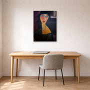 Unframed poster print of Amedeo Modigliani's Portrait of Jeanne Hebuterne displayed on a wall in an office