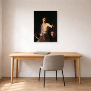 Unframed poster print of Caravaggio's 'David with the Head of Goliath' displayed on a wall in an office