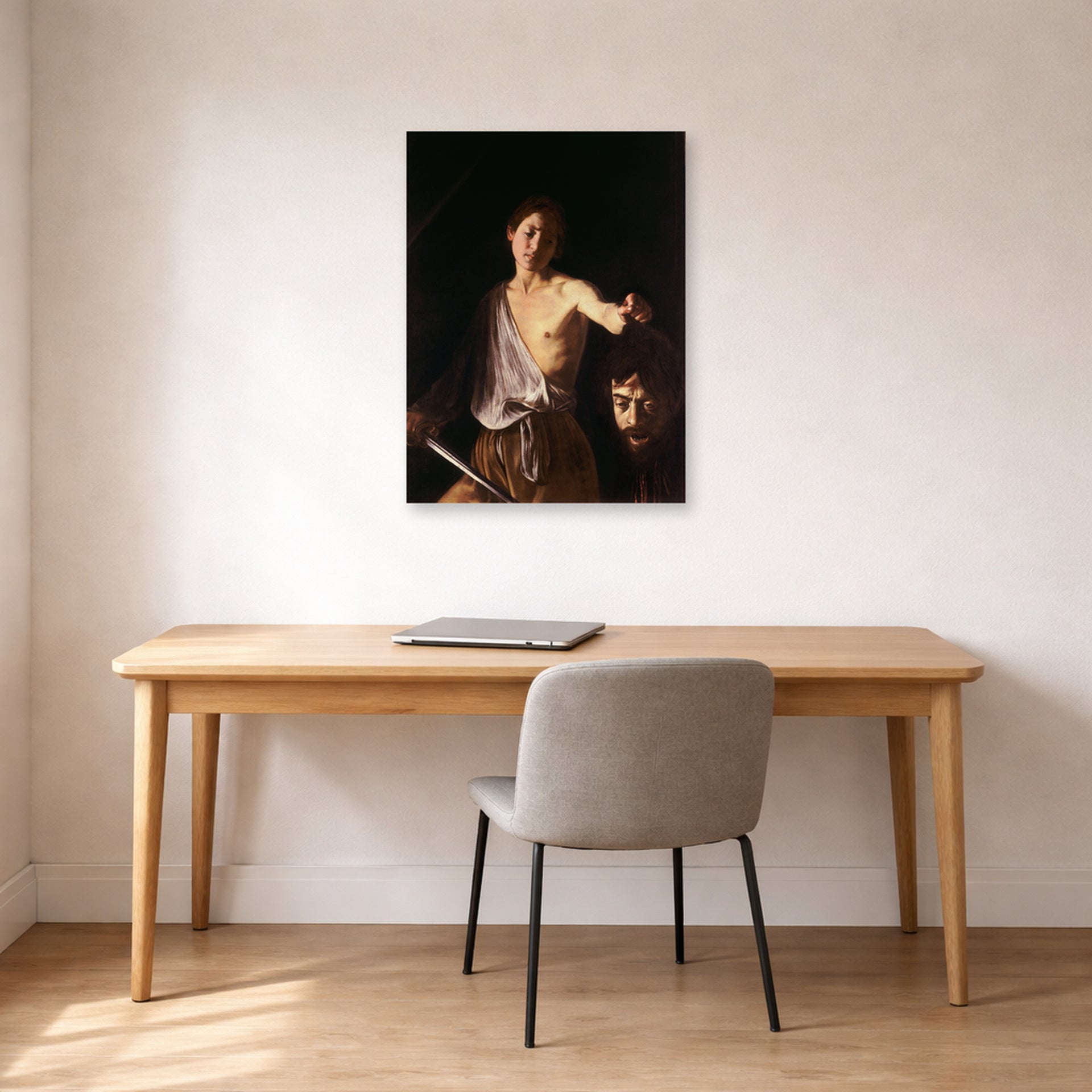 Unframed poster print of Caravaggio's 'David with the Head of Goliath' displayed on a wall in an office