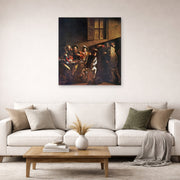 Unframed poster print of Caravaggio's 'The Calling of Saint Matthew' displayed on a wall in a living room