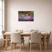 Gallery-wrapped canvas print of Claude Monet's 'The Artists Garden at Giverny' displayed on a wall in a dining room