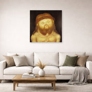 Unframed poster print of Fernando Botero's Head of Christ displayed on a wall in a living room