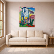 Unframed poster print of Franz Marc's Blue Horse displayed on a wall in a living room