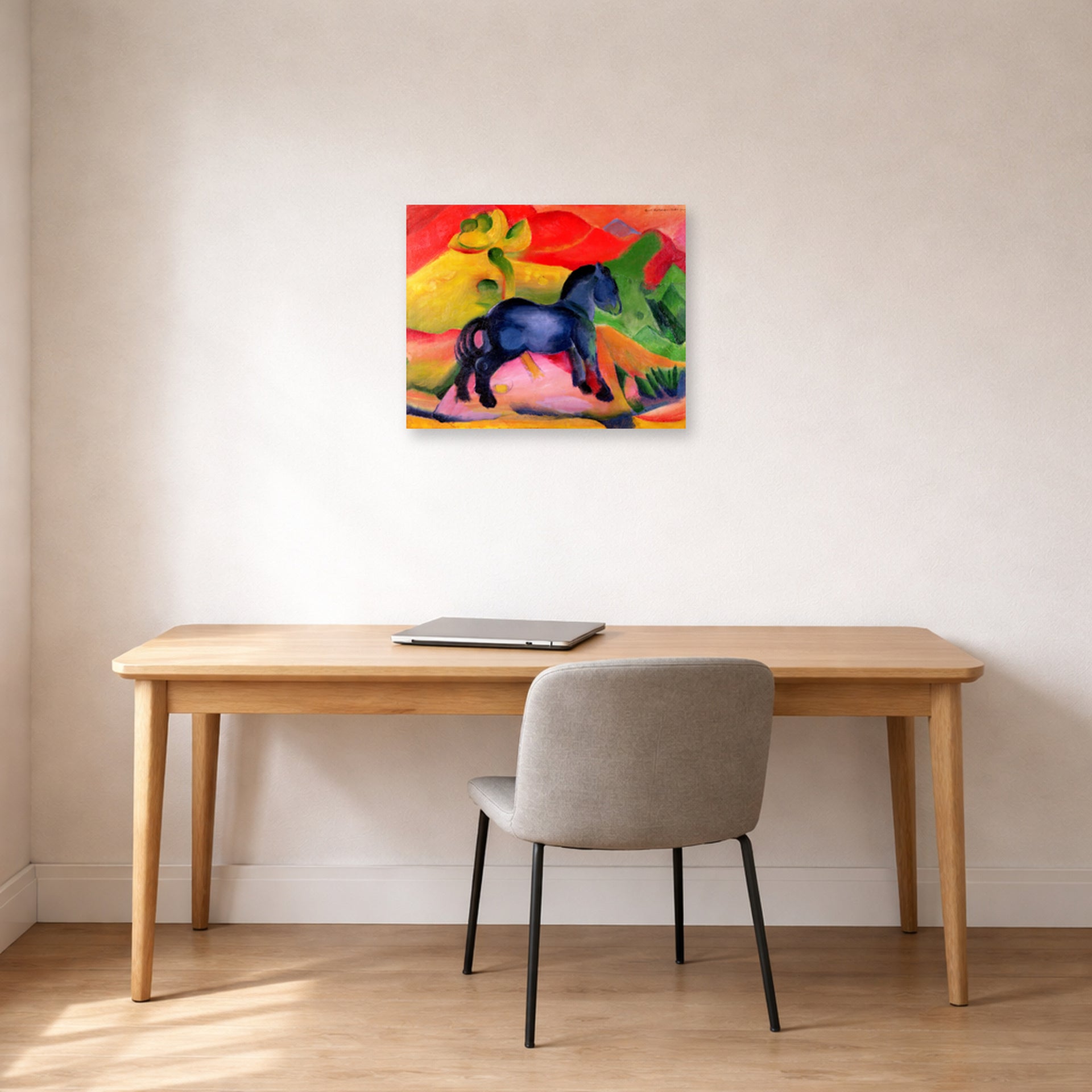 Unframed poster print of Franz Marc's The Little Blue Horse displayed on a wall in an office