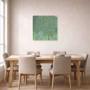Unframed poster print of Gustav Klimt's 'Rose Bushes Under Trees' displayed on a wall in a dining room