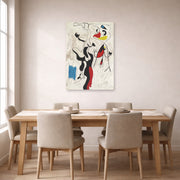 Unframed poster print of Joan Miró's 'Man and Woman' displayed on a wall in a dining room