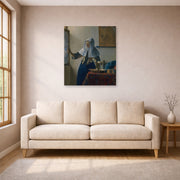 Unframed poster print of Johannes Vermeer's Young Woman with a Water Pitcher displayed on a wall in a living room