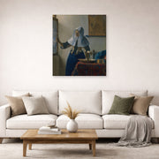 Unframed poster print of Johannes Vermeer's Young Woman with a Water Pitcher displayed on a wall in a living room
