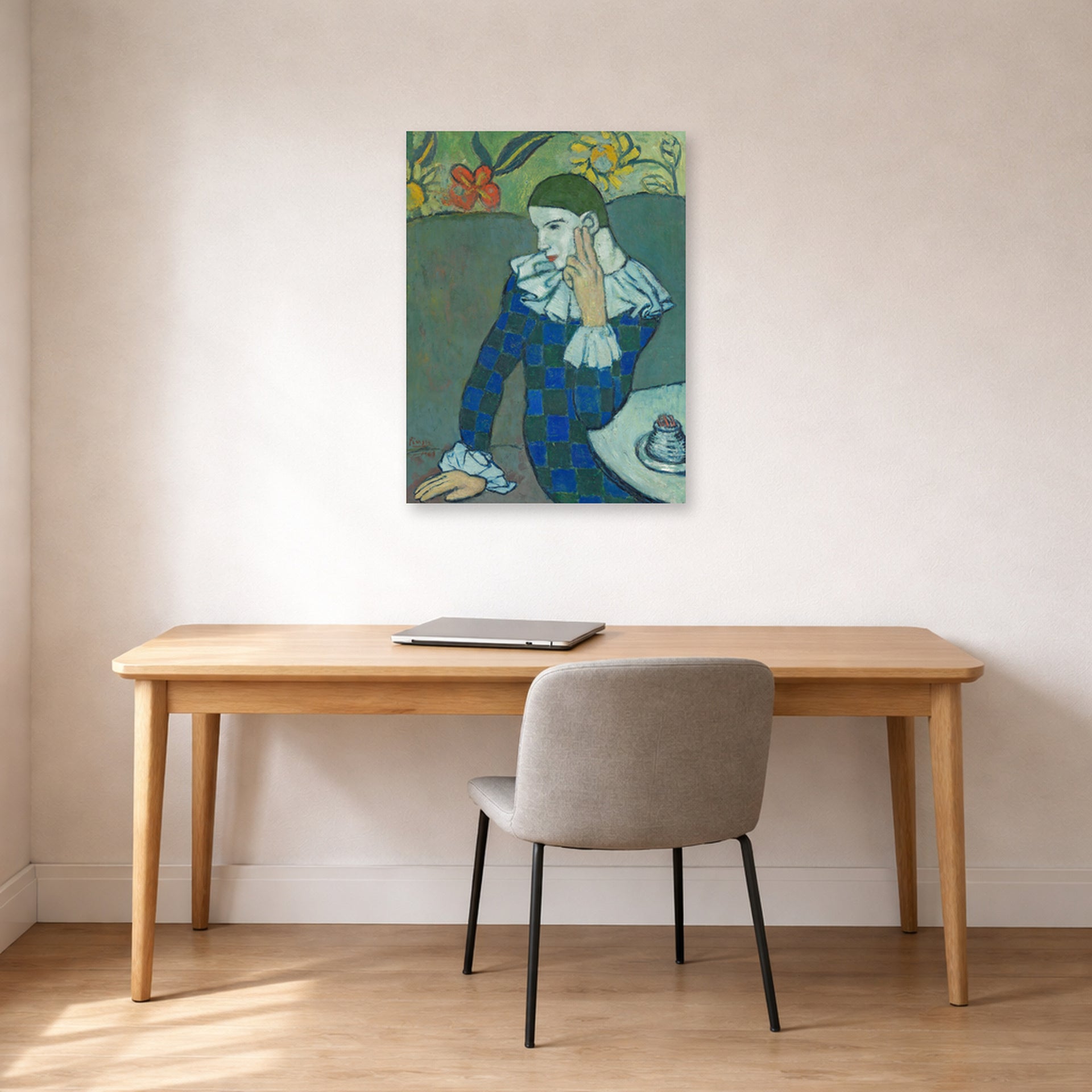 Unframed poster print of Pablo Picasso's 'Seated Harlequin' displayed on a wall in a home office
