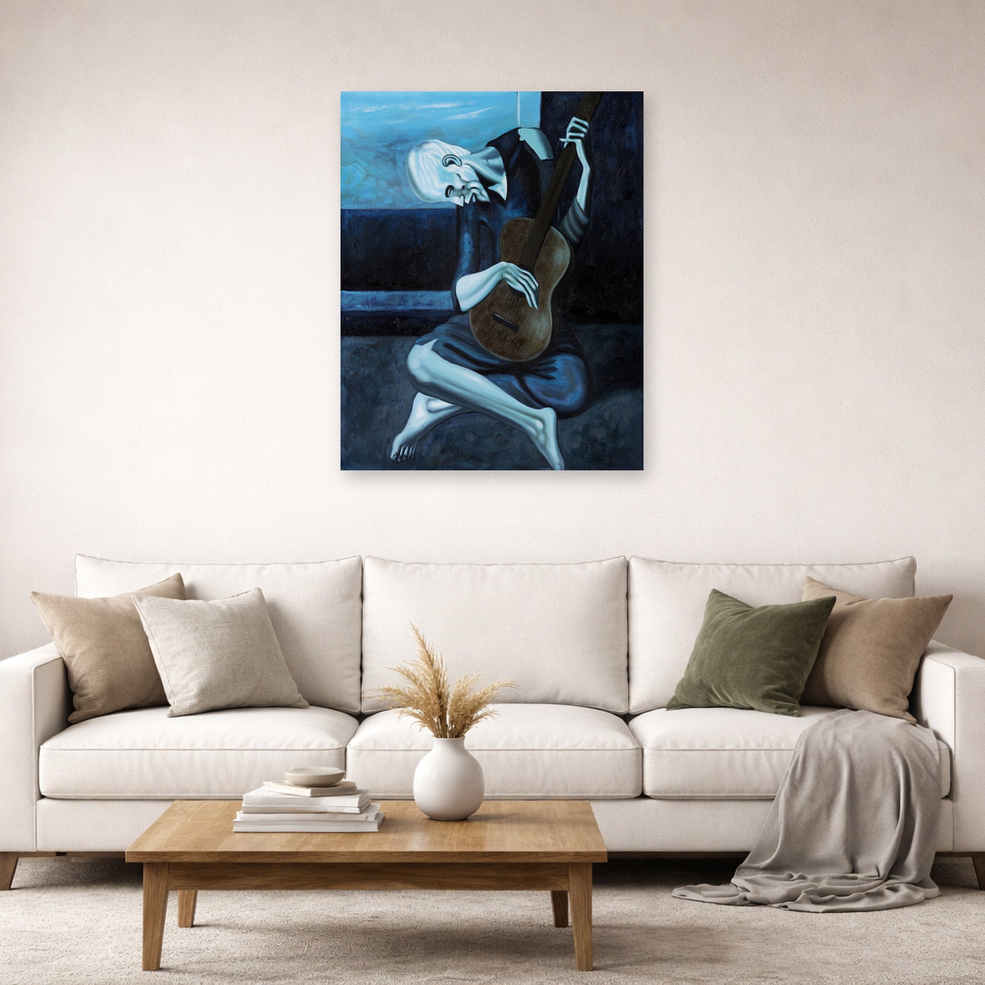 Unframed poster print of Pablo Picasso's 'The Old Guitarist' displayed on a wall in a living room