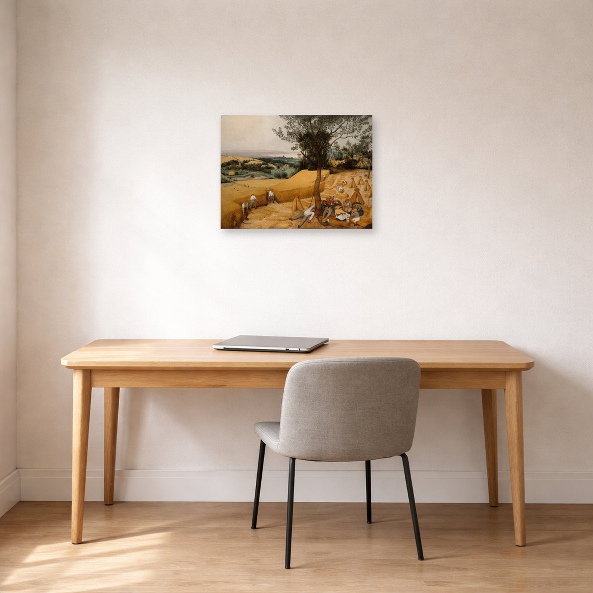 Unframed poster print of Pieter Bruegel the Elder's The Harvesters displayed on a wall in a home office