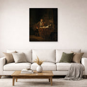 Unframed poster print of Rembrandt's A Scholar in His Study displayed on a wall in a living room