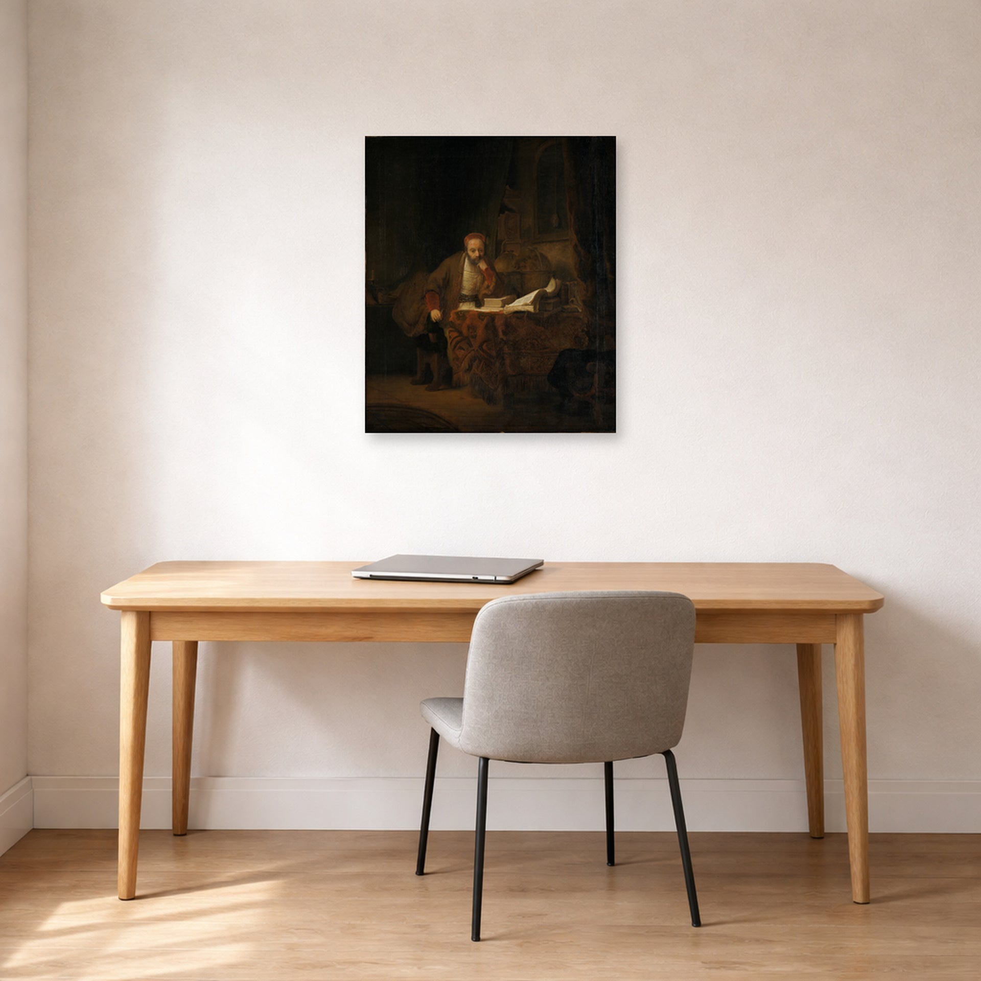 Unframed poster print of Rembrandt's A Scholar in His Study displayed on a wall in an office