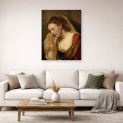Gallery-wrapped canvas print of Rembrandt's A Weeping Woman displayed on a wall in a living room