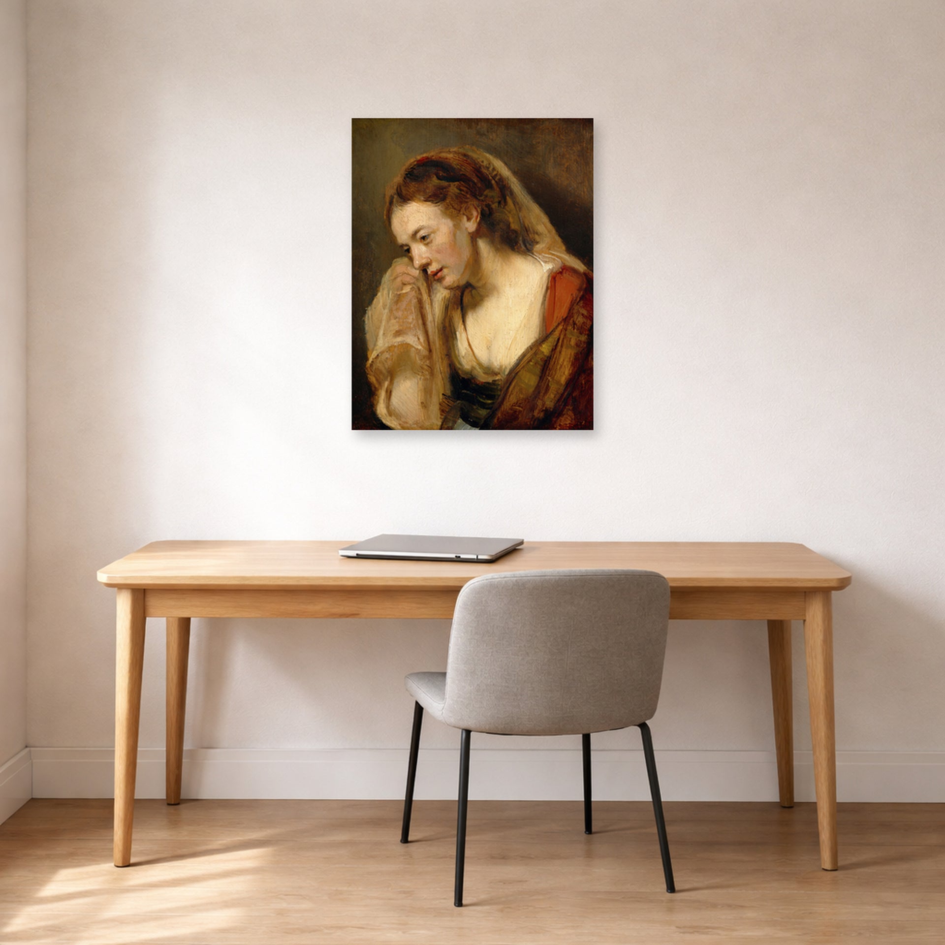 Unframed poster print of Rembrandt's A Weeping Woman displayed on a wall in an office