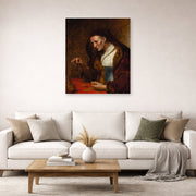 Unframed poster print of Rembrandt's An Old Woman Weighing Gold Coins displayed on a wall in a living room