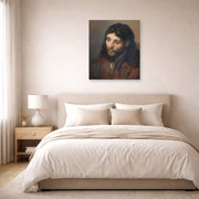 Unframed poster print of Rembrandt's Head of Christ displayed on a wall in a bedroom
