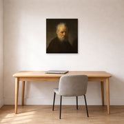 Unframed poster print of Rembrandt's Old Man with Beard displayed on a wall in an office