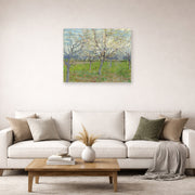 Unframed poster print of Vincent van Gogh's Orchard with Blossoming Apricot Trees displayed on a wall in a living room