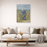 Unframed poster print of Vincent van Gogh's Peasant Woman Binding Sheaves displayed on a wall in a living room
