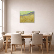 Unframed poster print of Vincent van Gogh's Wheatfield with a Reaper displayed on a wall in a dining room